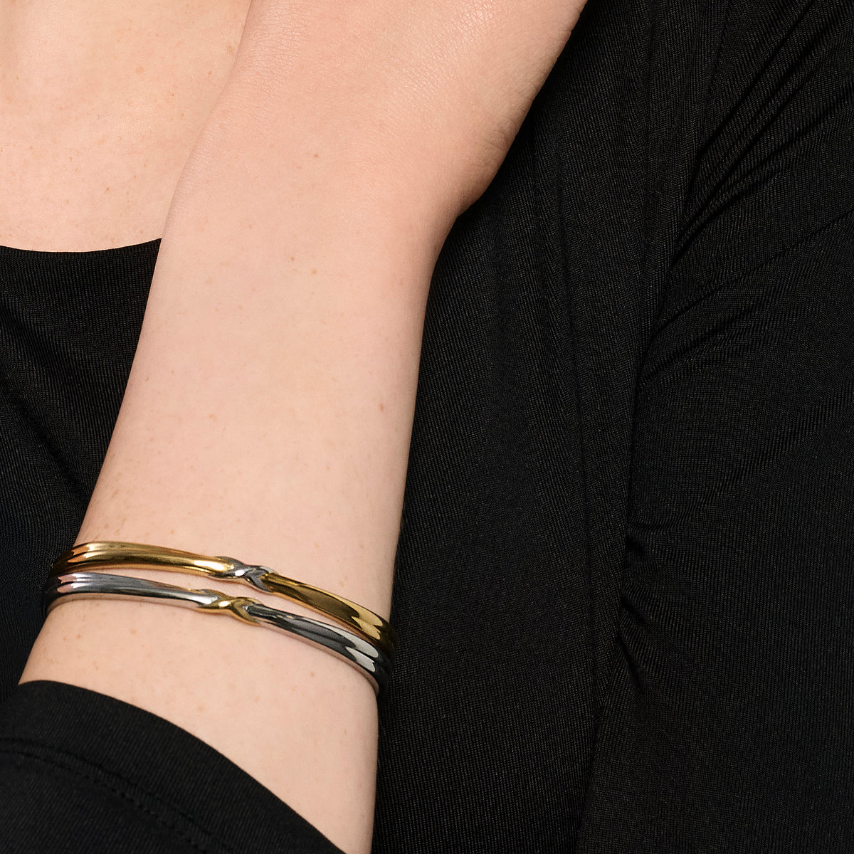 Two-tone stainless steel sculptural bracelet with twisted gold and silver design, modern minimalist jewelry, hypoallergenic non-tarnish durable bracelet, elegant everyday statement jewelry.